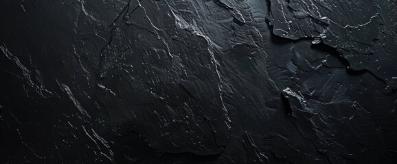 A close-up image of a dark gray slate stone texture, showcasing the intricate patterns and natural beauty of the material