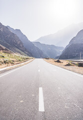 Automobile asphalt road in the mountains in the valley between rocky mountains, Pamir Highway in Tajikistan
