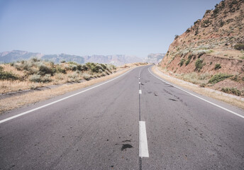 Automobile asphalt road in the mountains in the valley between rocky mountains, Pamir Highway in Tajikistan