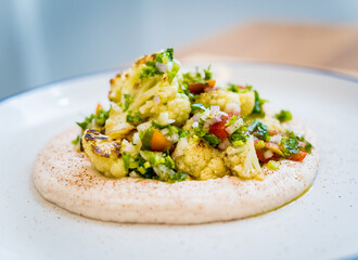 Tasty bean porridge with cauliflower and vegetables on white plate