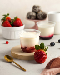 Yogurt with strawberry jam and berries on kitchen table