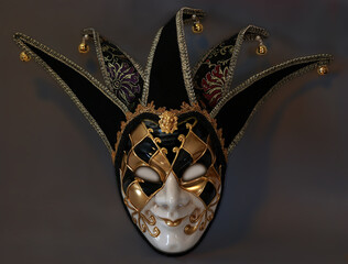 A scary jester full face mask isolated on a dark background