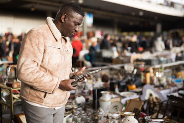 South African man selects antiques at a flea market