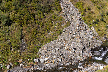 Scenic view of Foss River with cone of debris at Tremola mountain pass road at Swiss Gotthard mountain pass on a sunny late summer day. Photo taken September 10th, 2023, Gotthard, Switzerland.