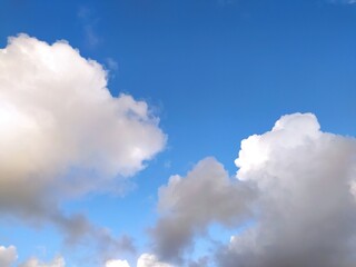 Clear blue sky texture and white fluffy cloud nature background. The sun shines bright in the daytime in summer