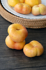 Closeup of flat peaches on the wooden table, taken in Shanghai, China