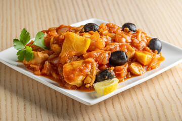 Stew with fried chicken, onion, olives and lemon.