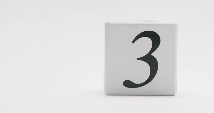 Simple white wooden block with the number nine printed in black. Isolated on a white background. White Wooden Block With Number Nine Isolated On White Background