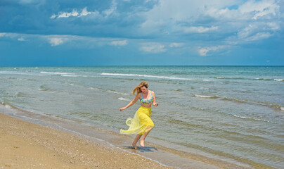 Fototapeta premium Concept of beach recreation, vacation time at warm climate. Girl on a sunny day at sea