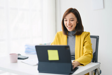 Young Professional Woman Working on Laptop in Modern Office Setting with Bright Natural Light and...