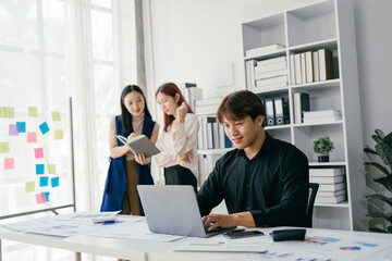 Young Professionals Collaborating in Modern Office Space with Laptops and Documents, Engaging in Productive Teamwork and Brainstorming Sessions