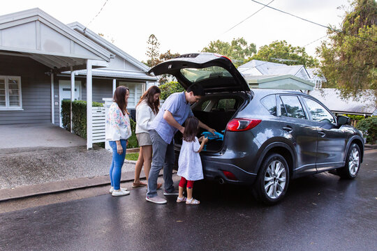 Family of four loading things inside the car boot for trip to park