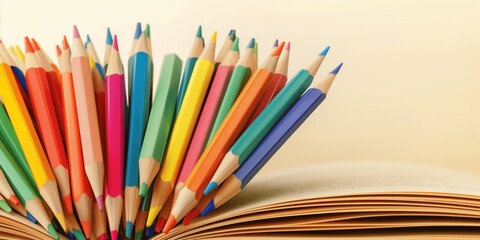 Fototapeta premium The vibrant colored pencils radiate from the pages of an open book, symbolizing creativity, learning, and the limitless joy of artistic exploration in education.