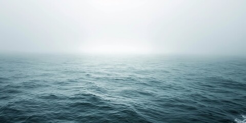 Obraz premium A tranquil view of a calm sea gently merging with a foggy sky, creating a soothing and peaceful atmosphere ideal for reflection and relaxation.