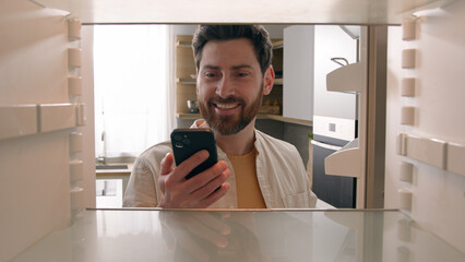 Hungry man guy open empty refrigerator poor crisis order food delivery with smartphone online...