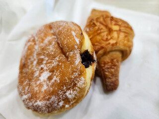 A close-up of delicious donuts with chocolate filling and a French croissant 