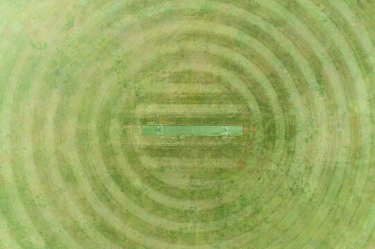 Aerial view of a grassy oval with a cricket pitch.