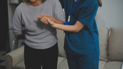 Female caregiver doing regular check-up of senior woman in her home.