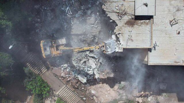  Excavator demolishing barracks for a new construction project. Aerial view.