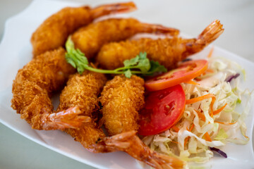 Fried shrimp served on plate with vegetable, n a restaurant