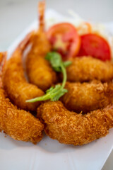 Fried shrimp served on plate with vegetable, n a restaurant