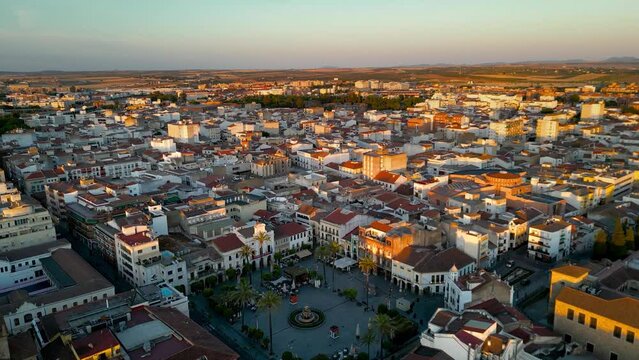 Panoramic aerial view of Spanish city MERIDA at sunset. Drone circling around Spain Square in the old town city. Beautiful sunset colours reflecting on buildings. Famous travel destination in Badajos.