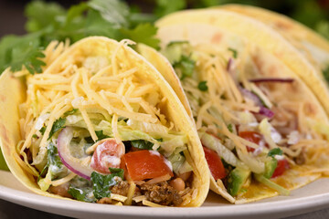 Taco with ground beef and avocado, cabbage and cheese. Mexican cuisine. Close-up.