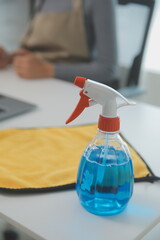 Woman cleaning table using rag and diffuser at home.