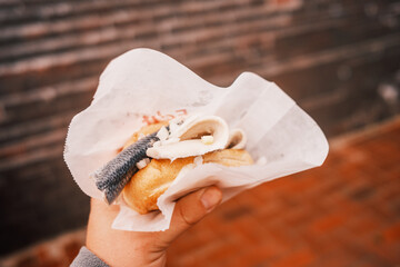 Fischbrötchen in einer Hand halten