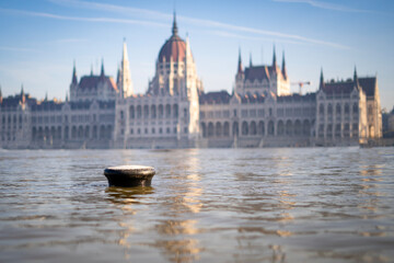 The neo-Gothic building of the Hungarian legislature, the Parliament with the river Danube flooding the quays in the foreground