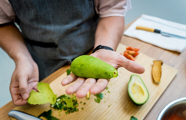 Chef at the kitchen preparing healthy quinoa bowl with avocado