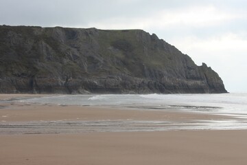 A photograph of a beach scene, Three Cliffs Bay, Gower, Swansea. 