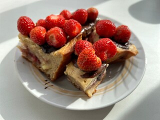 cottage cheese casserole with strawberries dipped in chocolate with fresh red berries on a porcelain plate on a white background