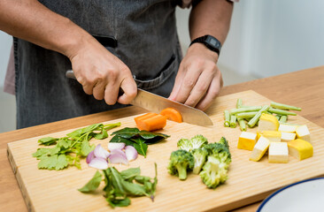 Chef at the kitchen preparing green curry with herbs and rice