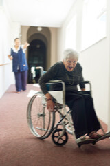 Senior woman, wheelchair and running from caregiver at nursing home, safety or dementia. Caretaker,...