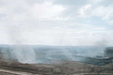 Aerial view of white smoke from forest fire rising up polluting atmosphere.=