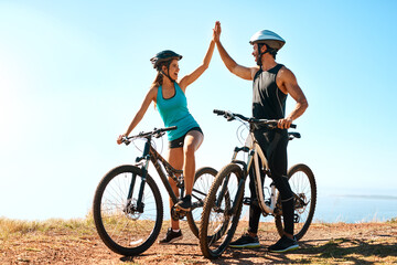 Fitness, couple and high five in mountain bike by nature for celebration, achievement and training goal. Happy people, man and woman with bicycle for exercise, workout and sports success in Germany © Chithambo/peopleimages.com