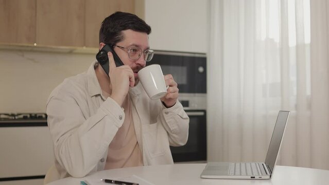 Man talking phone using mobile phone at kitchen. Male have conversation on smartphone ending coversation