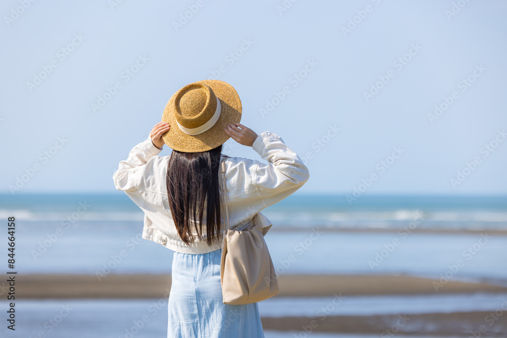 Wall mural tourist woman with hand raise up and look at the sea