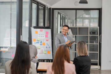 Obraz premium Group of Asian businessmen are presenting graphs on a whiteboard.