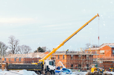 Construction Crane Lifting Materials During Snowy Winter Day