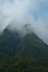 sharp mountain peaks surrounded by wisps of cloud on the summits