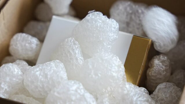 Eco packaging of parcels and white biodegradable filler. Box is filled with a filler safety for environment. Delivery of goods, parcels, delivery service, nature protection and recycling concept