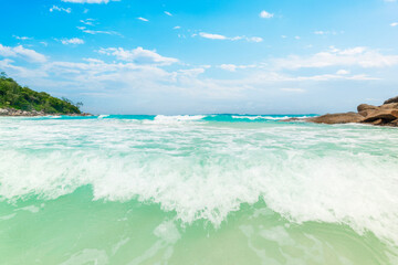 Small waves in a tropical beach under a blue sky