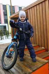 Child boy riding a bike in winter