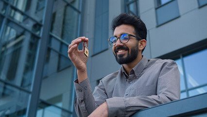 Smiling man Indian Arabian businessman real estate agent business investor hold bunch of keys new...