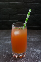 Grapefruit drink in a glass with a straw, mint and ice. Refreshing drink, freshly squeezed refreshing juice