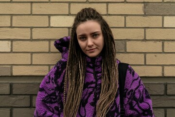 European woman with dreadlocks and piercings walks around the city on a day off