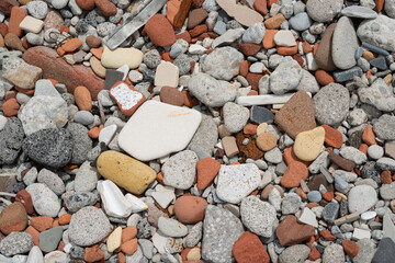 mostly broken, eroded, and smoothed construction waste at the edge of the lake