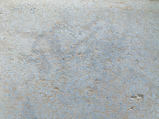 A white wall with a hole in it. The wall is cracked and has a rough texture
